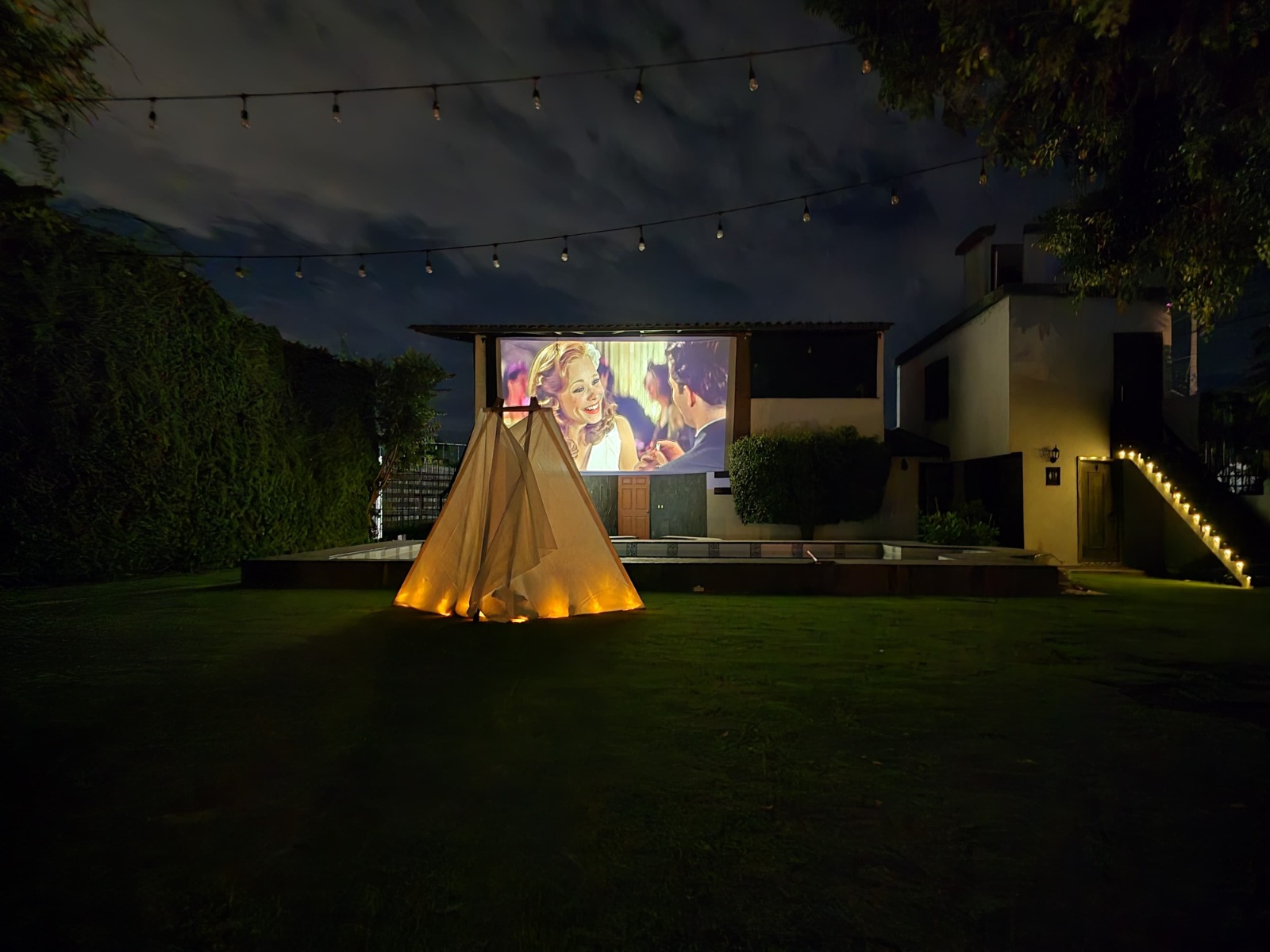 Teepee iluminado con película romántica en pantalla gigante — Godettia Cine Bajo las Estrellas