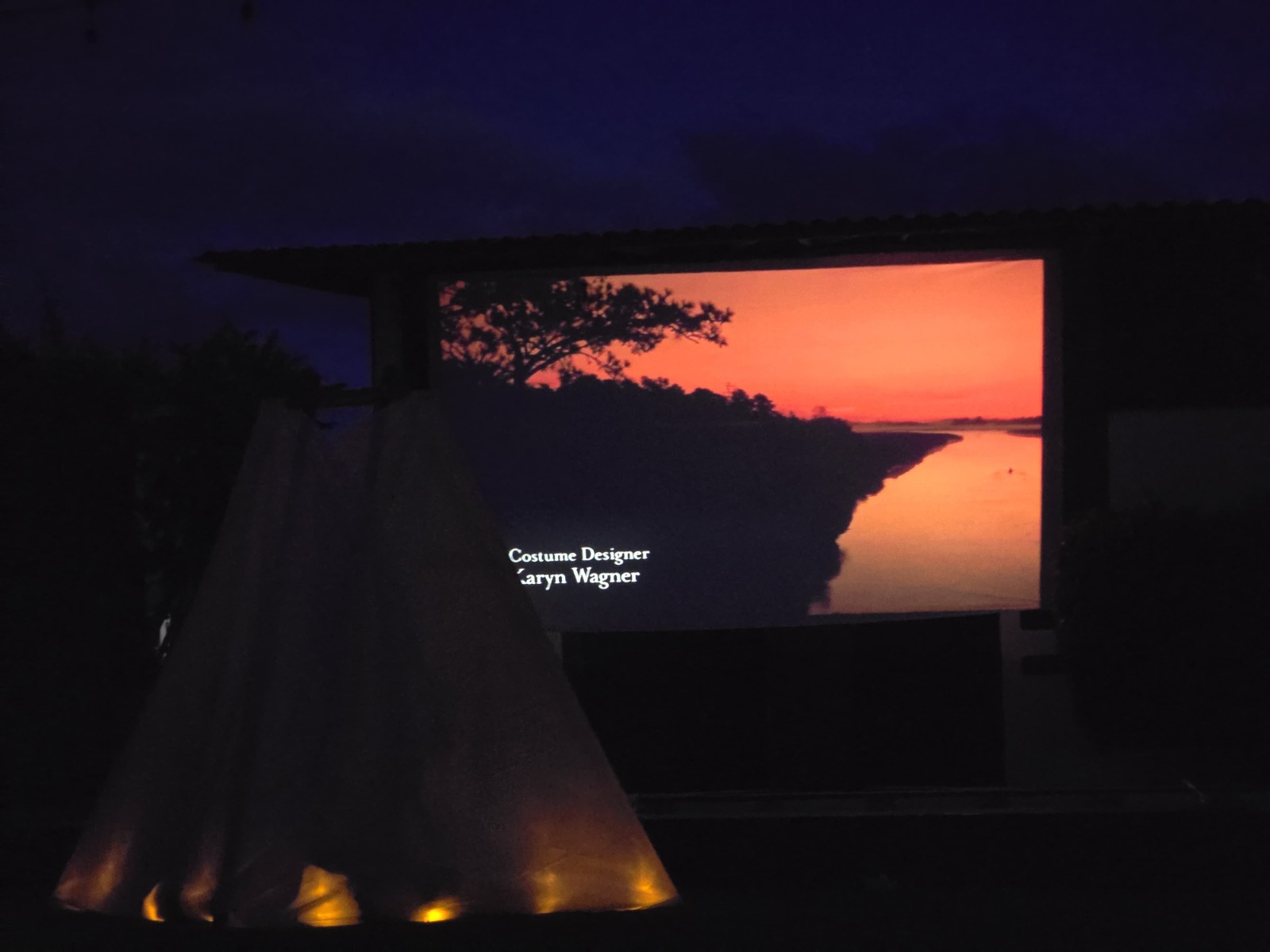 Teepee y pantalla gigante nocturna con cielo estrellado