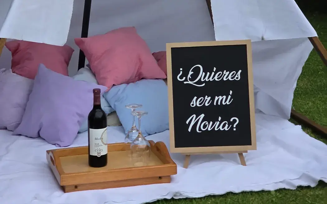 Botella de vino y copas sobre una charola dentro del teepee