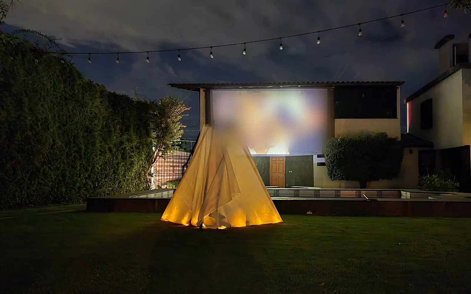 El teepee iluminado por dentro frente a la pantalla, de noche